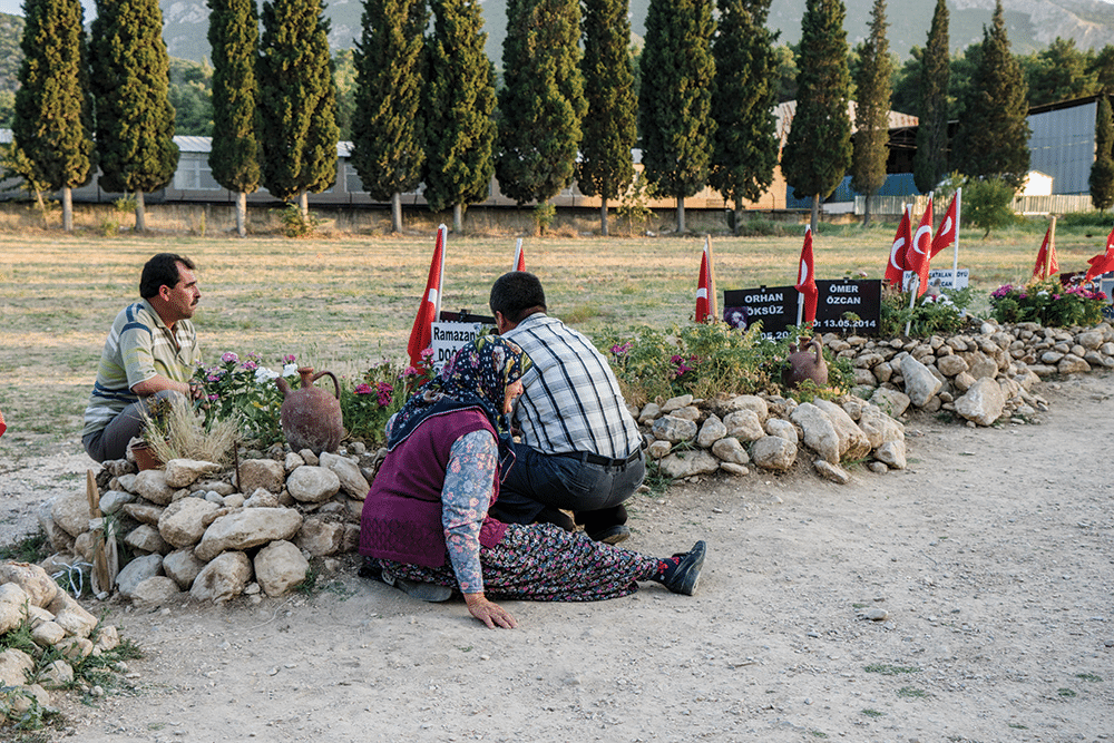 A mother with her two sons visit the grave of her third, Ramazan, who was killed in the Soma mine. Photo: Guy Martin