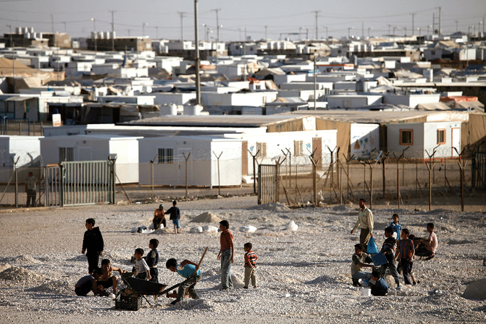 Syrian refugees work in the gravel yard, which is used to help protect their homes from rainwater. Photo: Mohammad Hannon/AP/Press Association Images