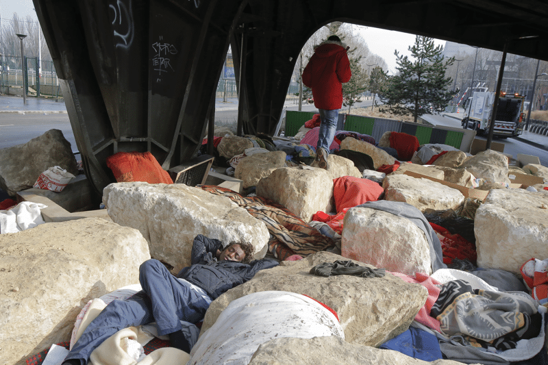 Migrants and refugees sleep in the spaces between boulders on 16th February 2017 at Porte de la Chapelle, Paris.  Photo: Michel Euler / AP / PA Images