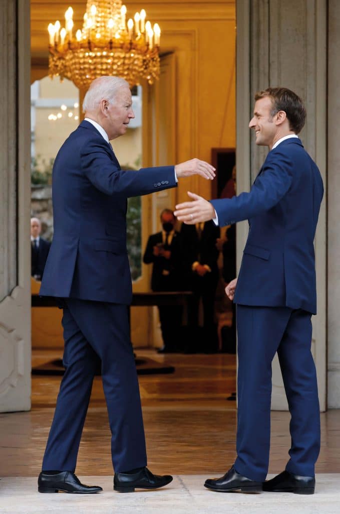 French President Emmanuel Macron (R) welcomes US President Joe Biden (L) before their meeting at the French Embassy to the Vatican in Rome on October 29, 2021