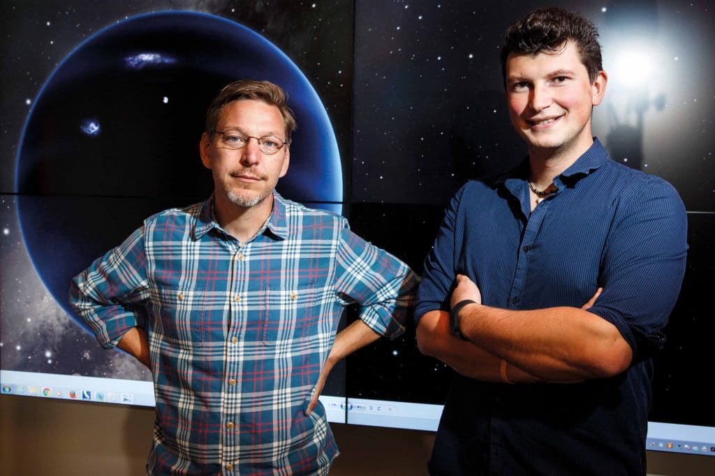  Professors Mike Brown and Konstantin Batygin, planetary astronomers at the California Institute of Technology, stand in front of an artistic impression of Planet Nine