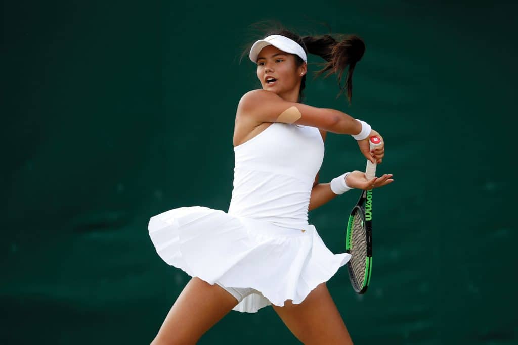 Raducanu plays in her Girls' Singles first round match on day seven of the Wimbledon Lawn Tennis Championships at All England Lawn Tennis and Croquet Club on July 9, 2018 in London, 
