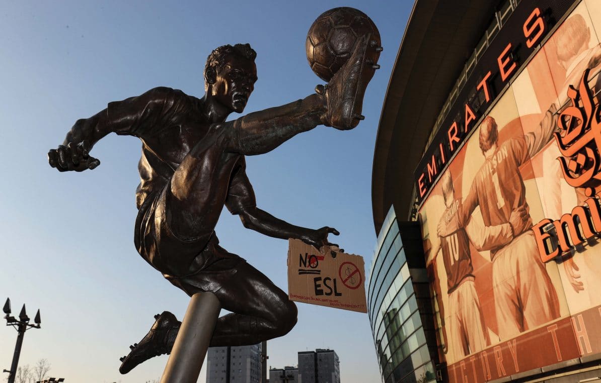 A sign protesting the European Super League taped to the hand of the Dennis Bergkamp statue outside Arsenal’s Emirates Stadium, London, 19th April 2021