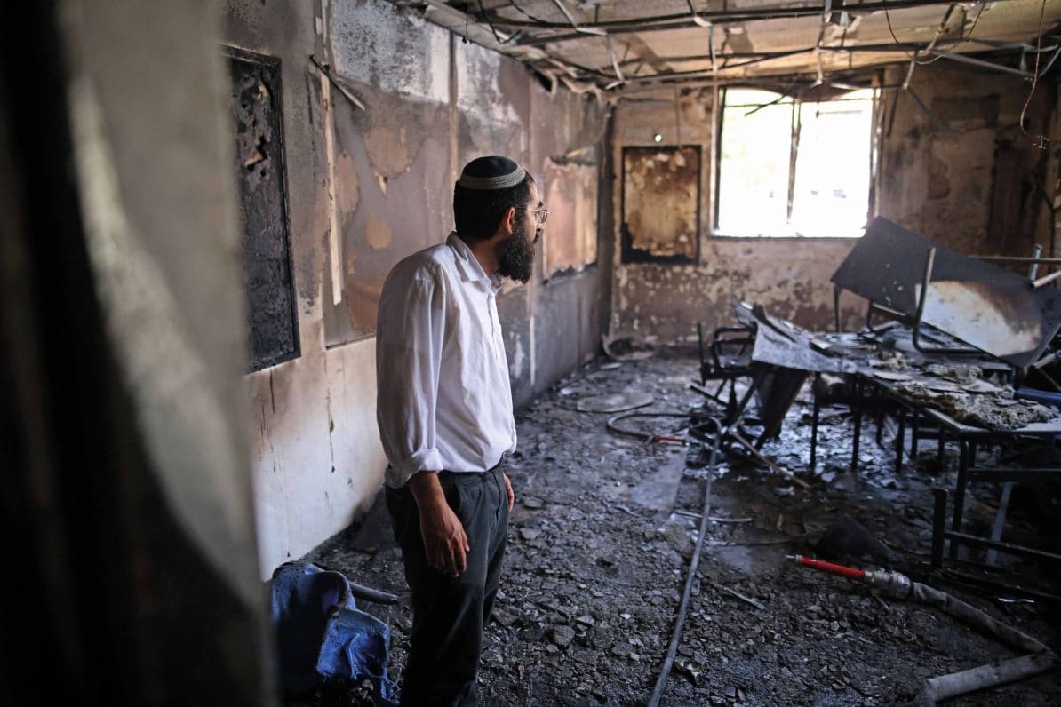 A rabbi inspects the damage at a torched religious school in Lod on 11th May 2021