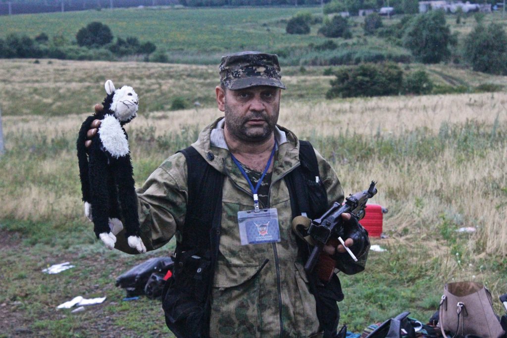A separatist commander known as ‘Grumpy’ brandishes a child’s toy amid the debris of flight MH17