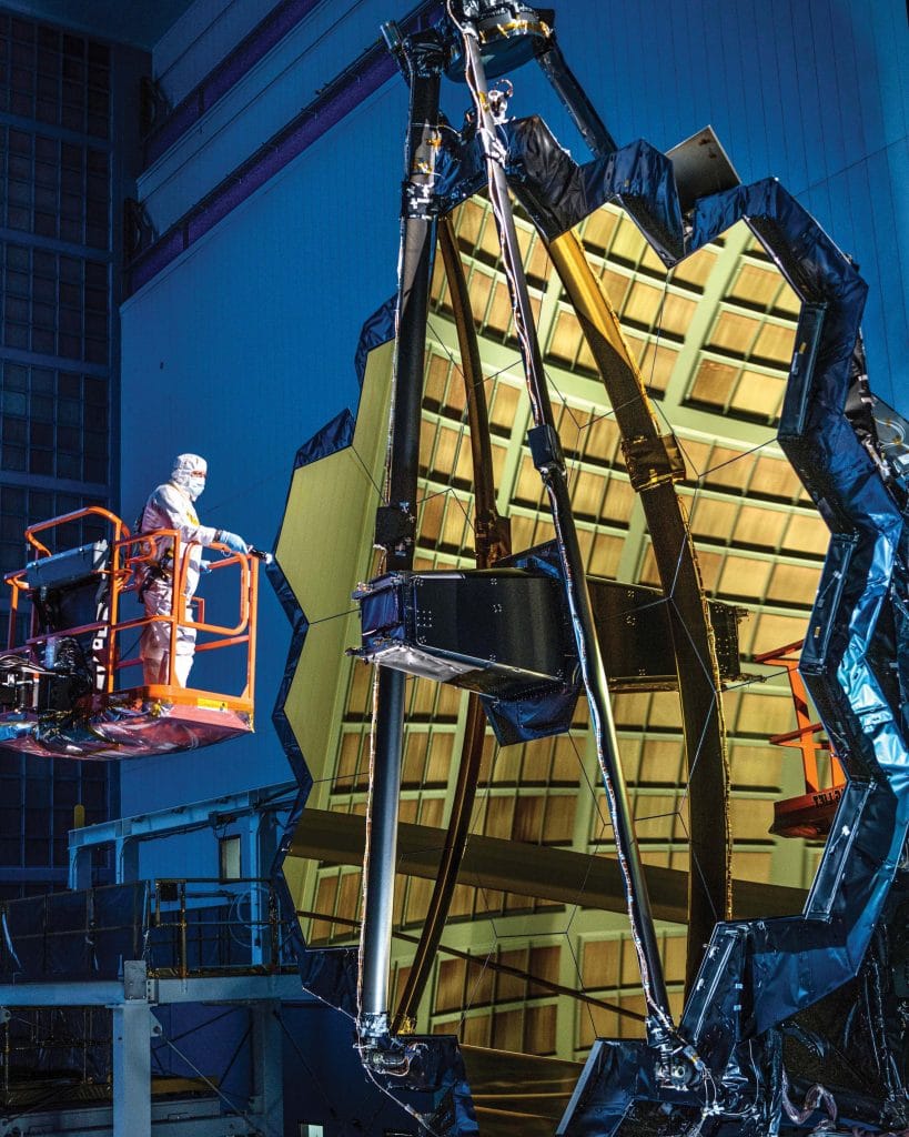 Technician George Mooney inspects a mirror on the James Webb telescope following a test, October 2016