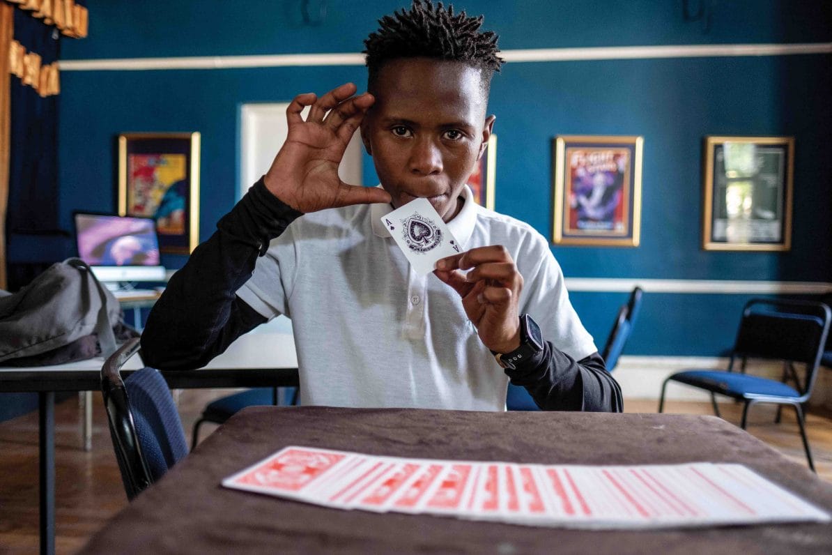 Duma Mgqoki, a student at the Cape Town College of Magic, practises a card trick in an empty classroom