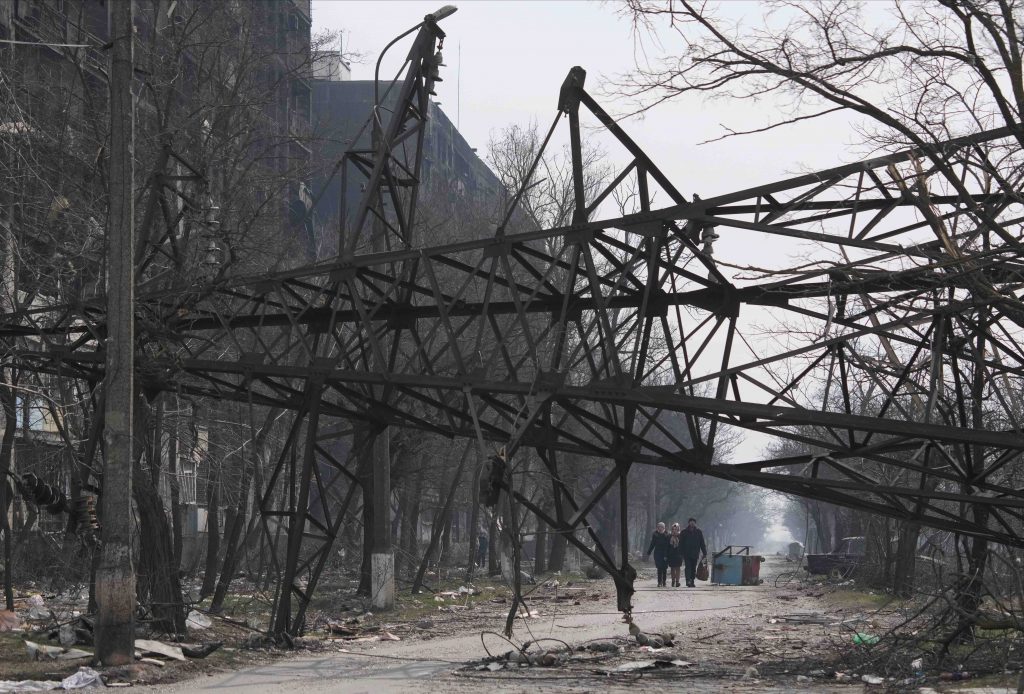Evacuees approach a collapsed electrical pylon, along a humanitarian corridor from the city of Mariupol, 26th March 
