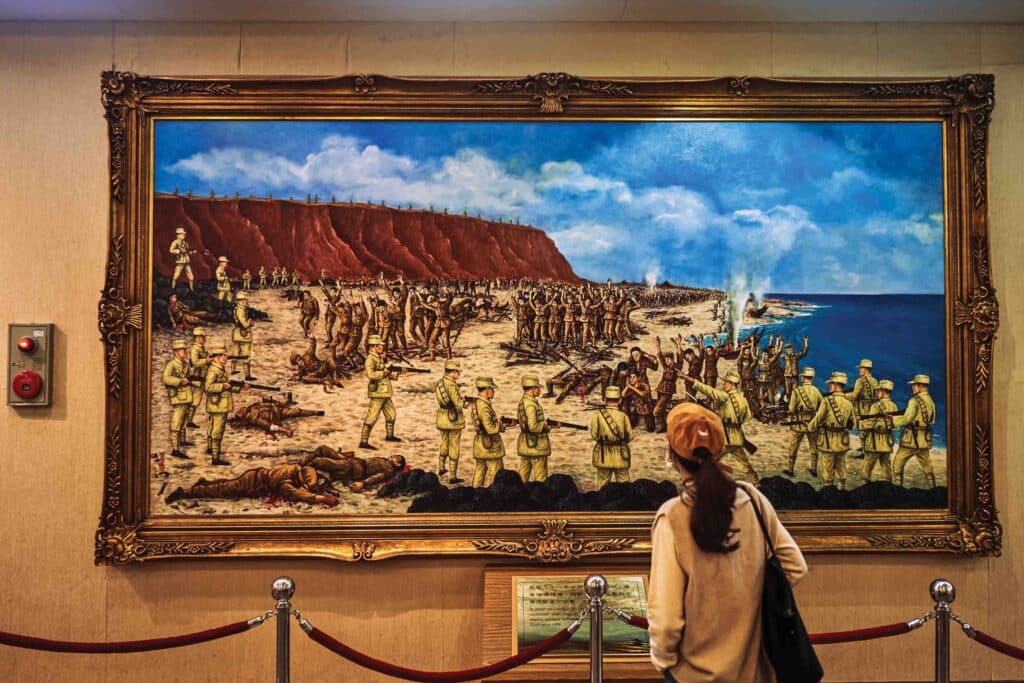 A visitor looks at a painting depicting the fierce 1949 battle of Guningtou, at the Guningtou Battle Museum on Kinmen