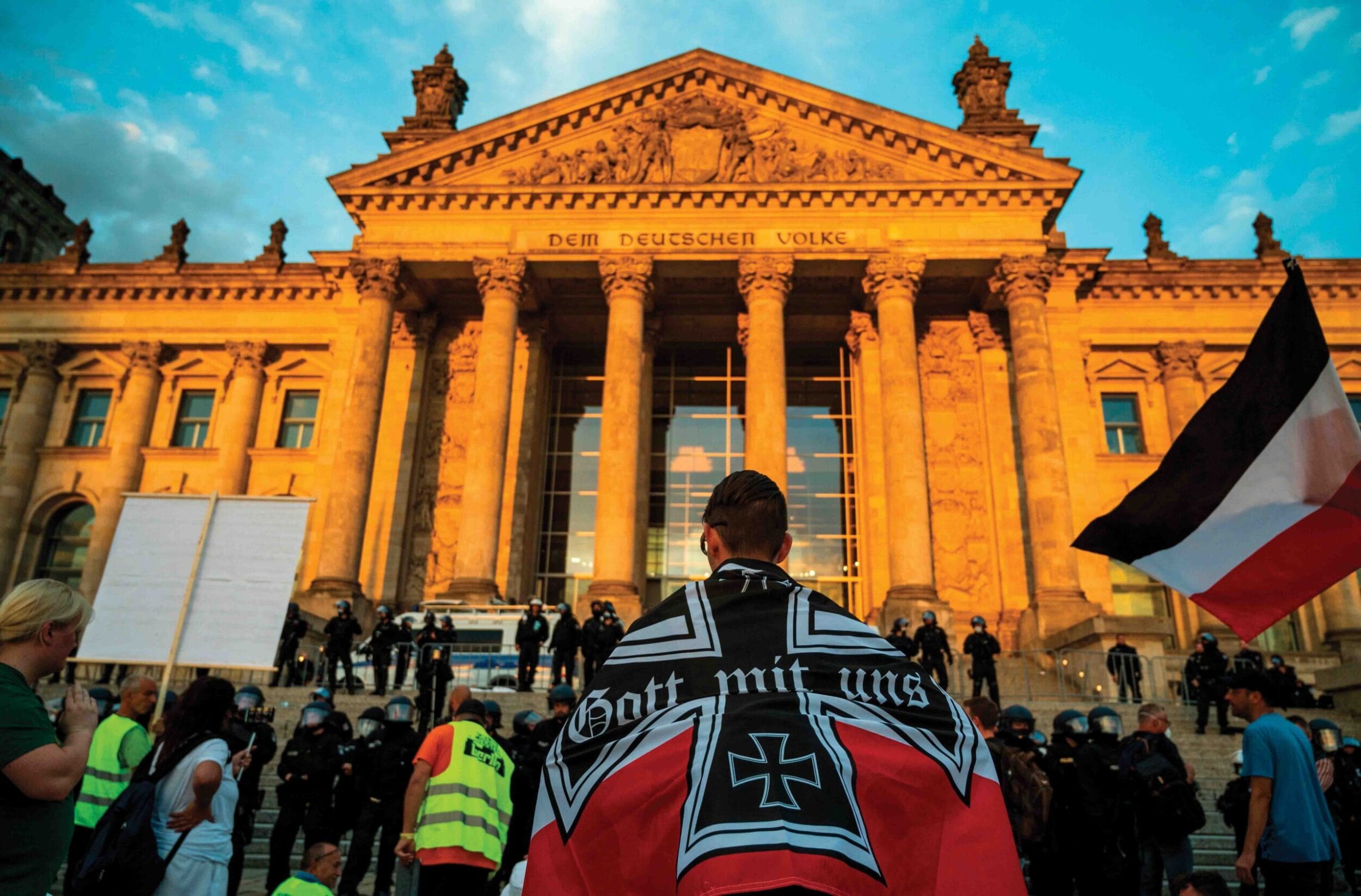 A demonstrator wrapped in a flag of the German empire in front of the Reichstag building after protesters tried to storm it at the end of a demonstration against Covid-19 restrictions, 29th August 2020
